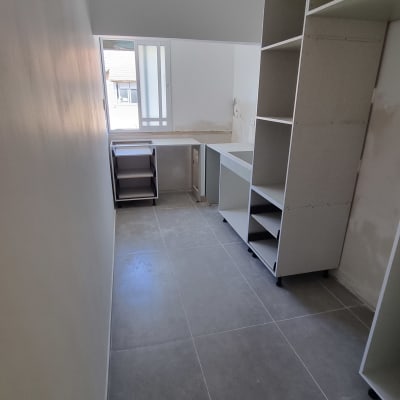 חדר עם ארונות פתוחים ורצפת אריחים אפורה