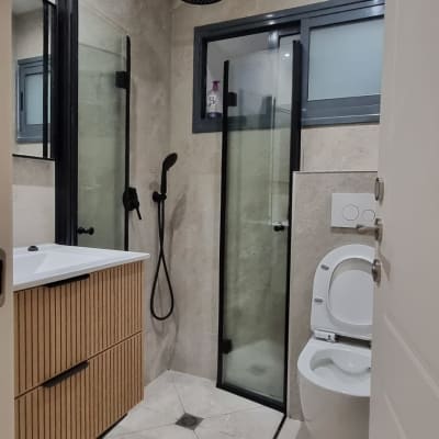 חדר אמבטיה עם מקלחת ושירותים מודרניים