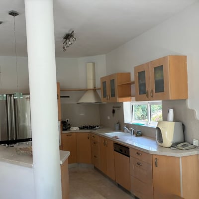 מטבח מודרני עם ארונות עץ ומכשירי חשמל.