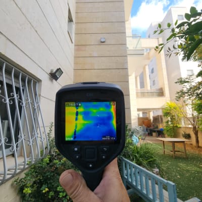 מד חום תרמי מציג דליפות חום על קיר חיצוני
