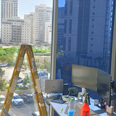 סולם עץ, מחשבים ומסכים על שולחן במשרד