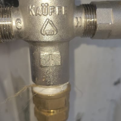 שסתום מתכת עם חיבורים וצינור שחור