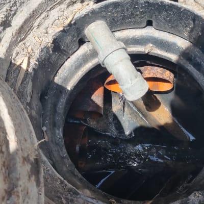 צינור מתכת בתוך פתח ביוב עם מים