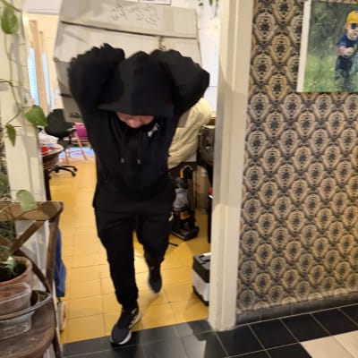 אדם נושא קופסה גדולה בתוך בית