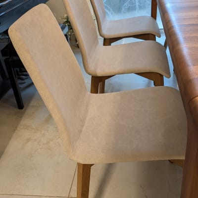 שלושה כיסאות מרופדים ליד שולחן עץ