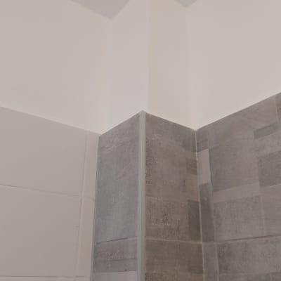 פינת קיר צבועה עם אריחים אפורים ולבנים