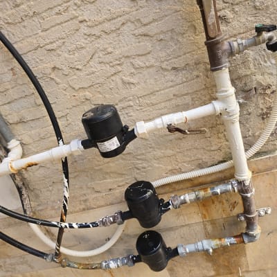 צנרת מים עם ברזים ומחברים על קיר חיצוני