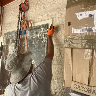 אדם עובד על קיר עם כלי עבודה ושרשרת