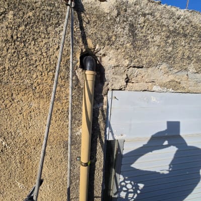 עבודת איטום על קיר עם צינור וחבל בטיחות