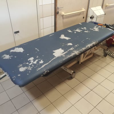 שולחן מרופד בלוי עם כלים על רצפה מרוצפת