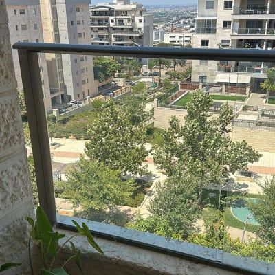 מעקה זכוכית במרפסת עם נוף עירוני