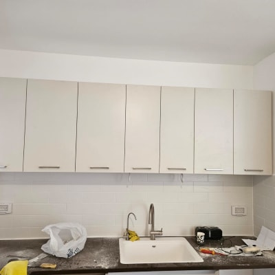 ארונות מטבח לבנים מעל כיור וברז נירוסטה