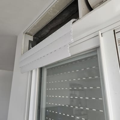 תריס גלילה לבן פתוח חלקית עם מנגנון חשוף