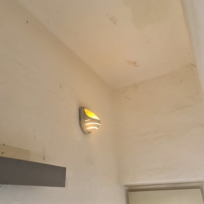 מנורת קיר דולקת על קיר לבן