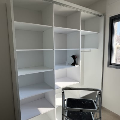 ארון לבן עם מדפים, סולם ומברגה