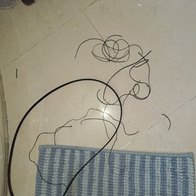 חוטים שחורים על רצפה ליד שטיח אפור