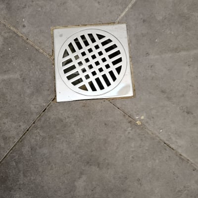 רצפת אריחים עם פתח ניקוז עגול