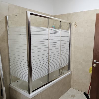 חדר אמבטיה עם דלת זכוכית וכלים על הרצפה