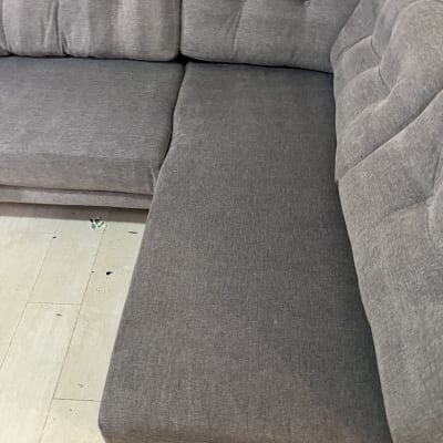 ספה אפורה על רצפת עץ בהירה