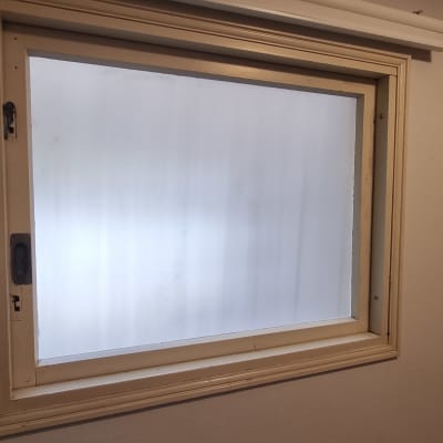 חלון זכוכית עם מסגרת עץ על קיר פנימי