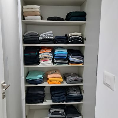 ארון בגדים מסודר עם חולצות ומכנסיים מקופלים