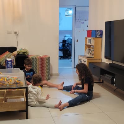 מדף ספרים מאורגן ליד טלוויזיה גדולה בסלון