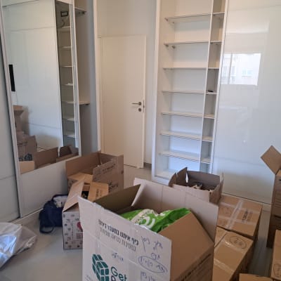 חדר עם קופסאות קרטון לאריזה ומדפים ריקים