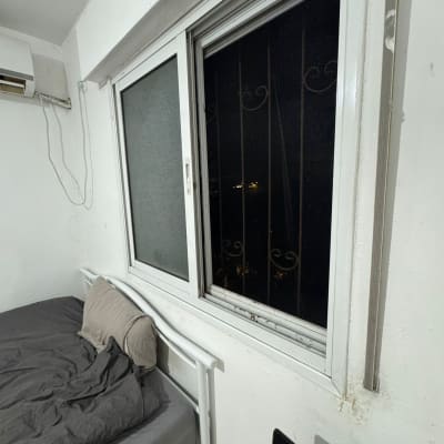 חלון עם סורגים בחדר שינה, מיטה ליד החלון