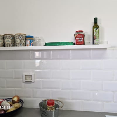 מדף עם קופסאות תבלינים ושמן זית במטבח