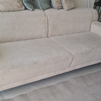 ספה בהירה עם כריות בחדר מגורים