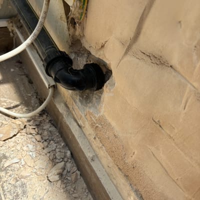 צינור פלסטיק שחור מחובר לקיר עם חיבורים