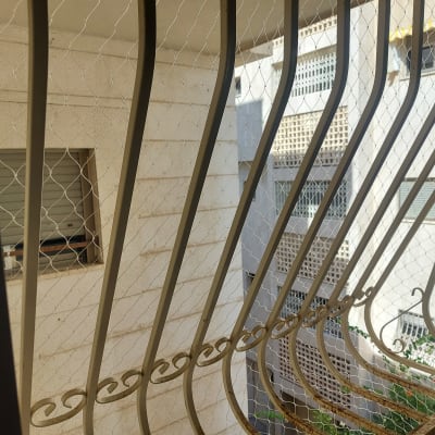 רשת מתכת על חלון למניעת כניסת יונים