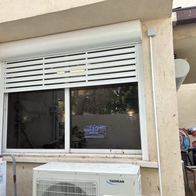 תריס אלומיניום לבן על חלון זכוכית