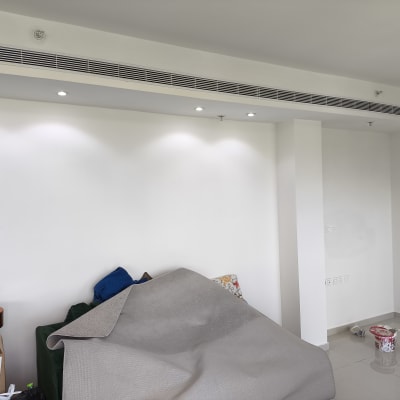 קיר צבוע בלבן עם פחית צבע ומברשת על הרצפה