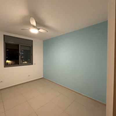 קיר צבוע בכחול בחדר ריק עם מאוורר תקרה