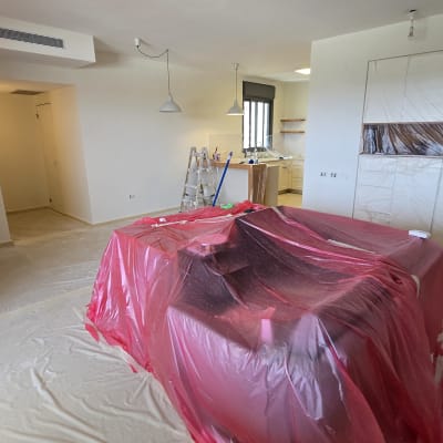 חדר עם כיסוי פלסטיק אדום, סולם וכלי צביעה