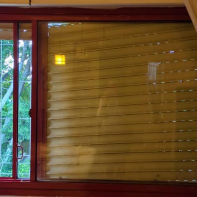 תריסים סגורים על חלון עם מסגרת אדומה