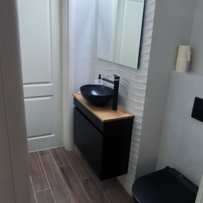 חדר אמבטיה עם כיור שחור וברז מודרני