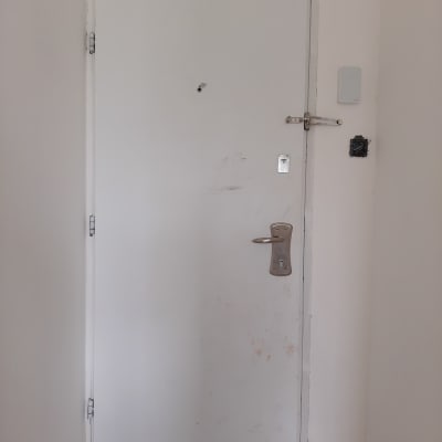 דלת לבנה עם ידית ומנעול בריח עליון