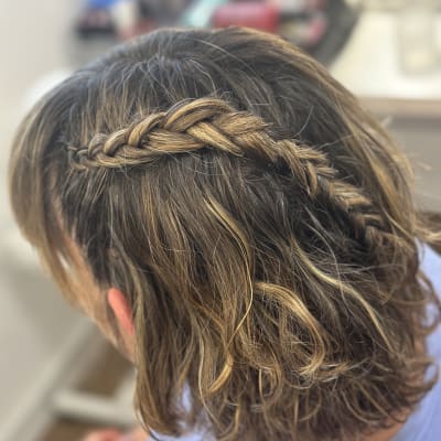 צמה קלועה בשיער חום עם גוונים בהירים