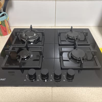 כיריים גז שחורות עם ארבעה מבערים במטבח