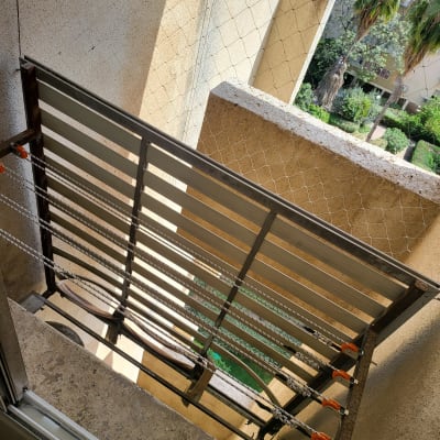 מתקן כביסה עם חבלים וגלגלות על קיר חיצוני