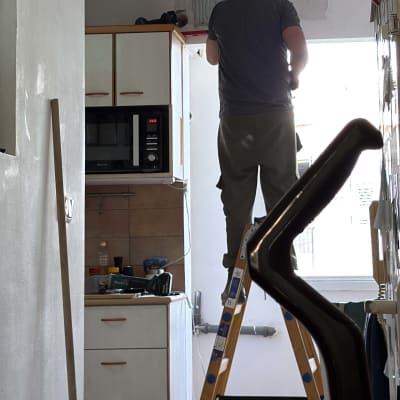 אדם על סולם מתקין מזגן במטבח