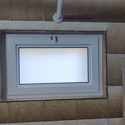 חלון אלומיניום בחדר אמבטיה עם אריחים חומים