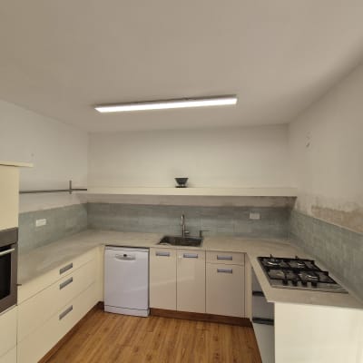 מטבח עם ארונות חדשים, כיור וברז מותקנים.