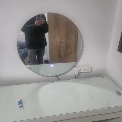 שקעי חשמל על קיר ליד מראה עגולה