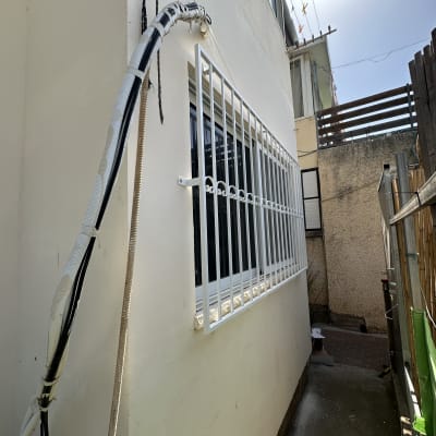 סורגי מתכת לבנים על חלון קיר חיצוני