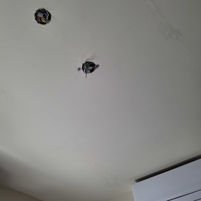 שני חורים בתקרה עם חוטי חשמל חשופים