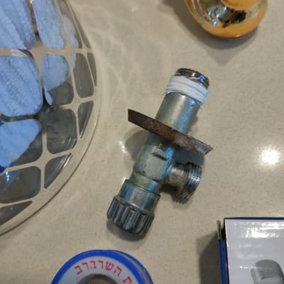 ברז מתכת עם סרט טפלון על שולחן