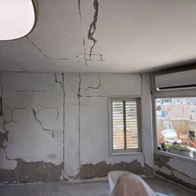 קירות עם סדקים ותיקונים, חלון ומזגן